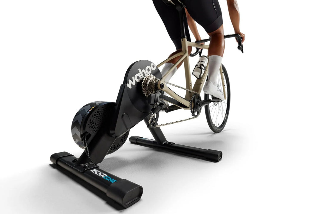Person using a stationary bike trainer on a white background