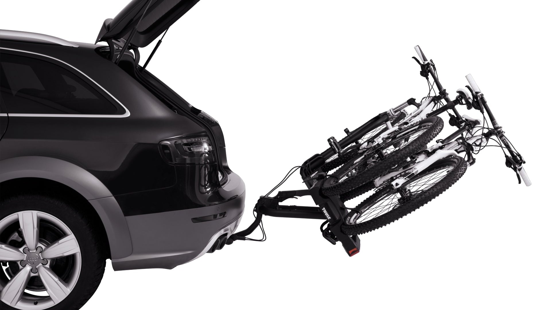 Car with open trunk and bike rack holding a folded bicycle on a white background