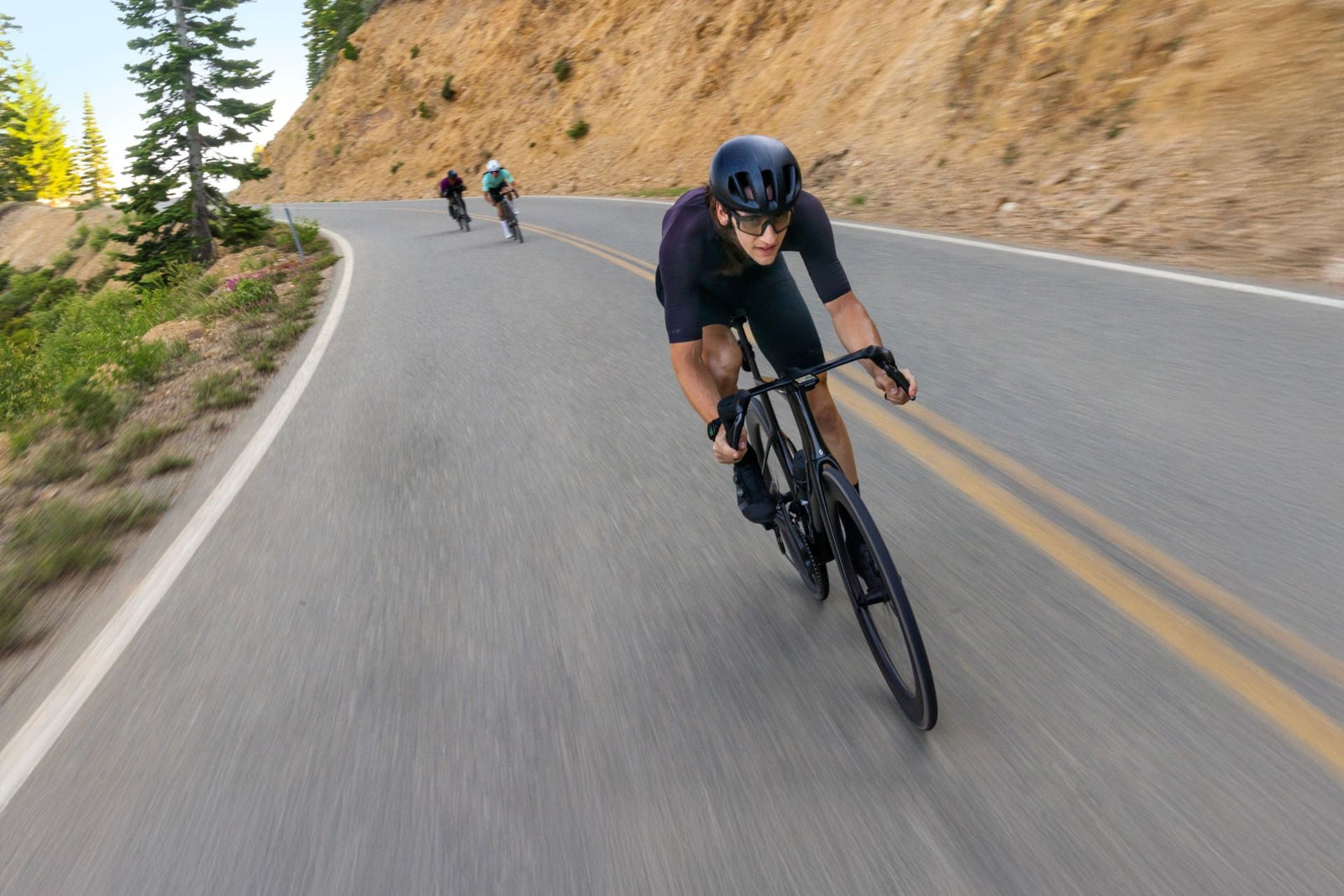 Cyclist riding on a winding road with a scenic background