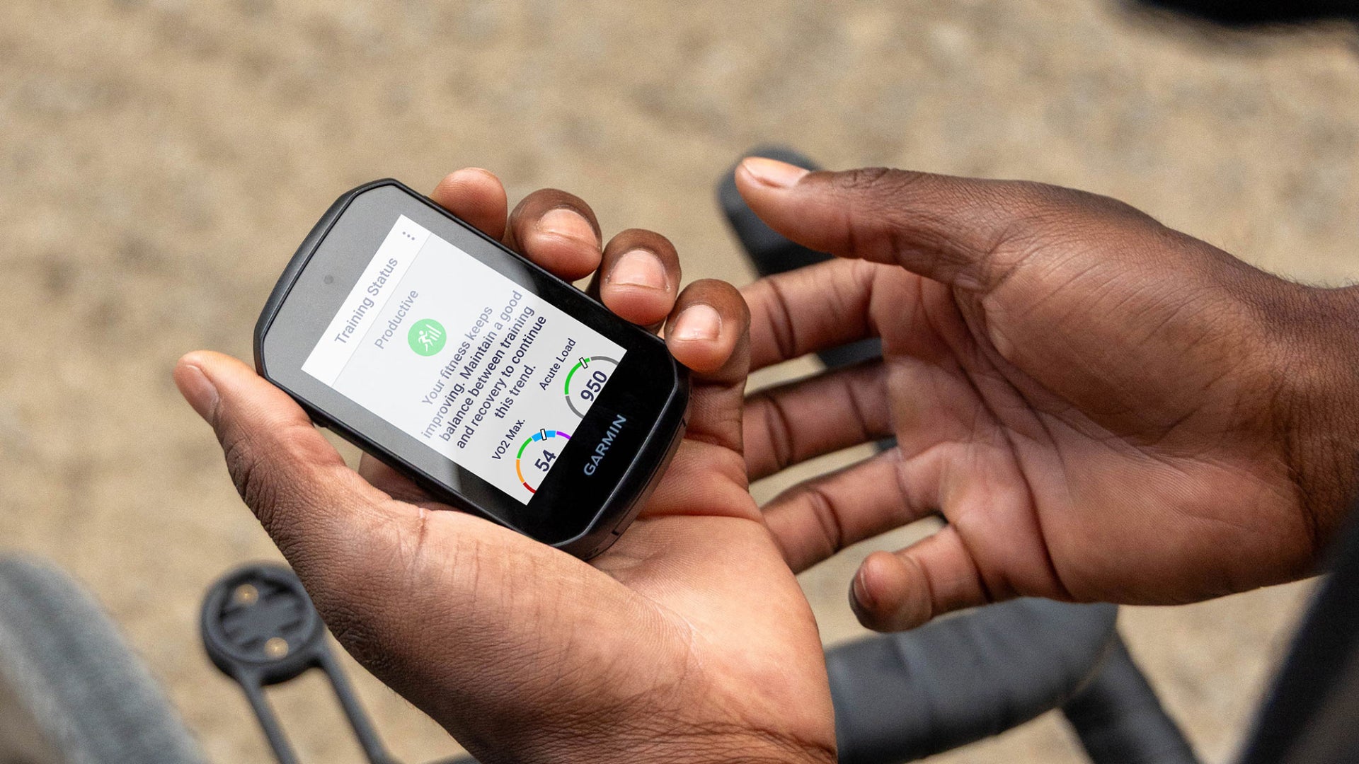Person holding a garmin gps with a visible screen, outdoors.